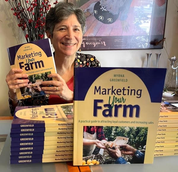 Myrna Greenfield with her book Author Myrna Greenfield holds a copy of her book, Marketing Your Farm